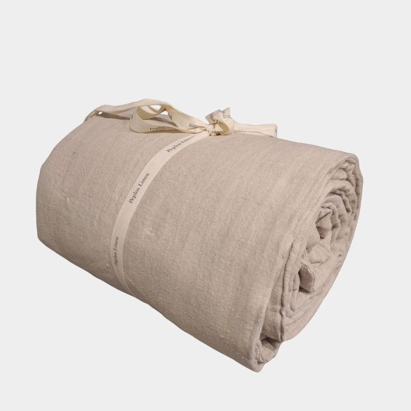 Handmade natural linen quilt with cotton fill, rolled and tied with ribbon.