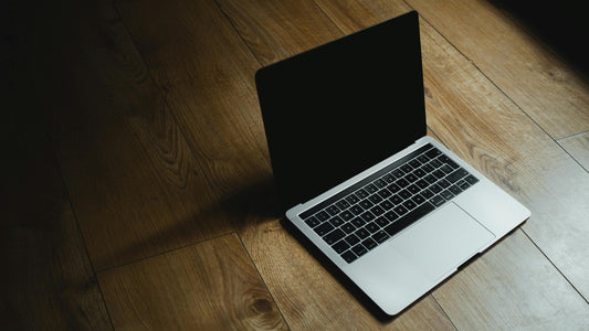 Open MacBook laptop on a rustic wooden desk, displaying a blank screen—ideal workspace setup for creative entrepreneurs or remote work.