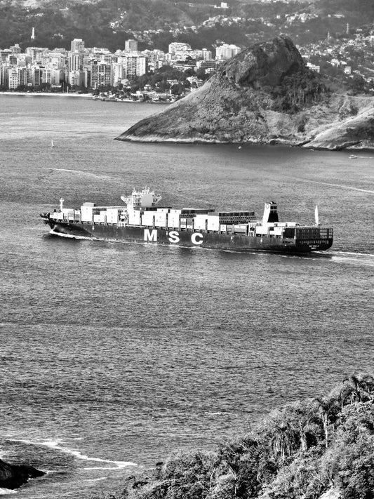 Cargo ship crosses calm ocean, stacked with containers—symbol of global trade and sourcing for heirloom linen quilts and ethical textiles.
