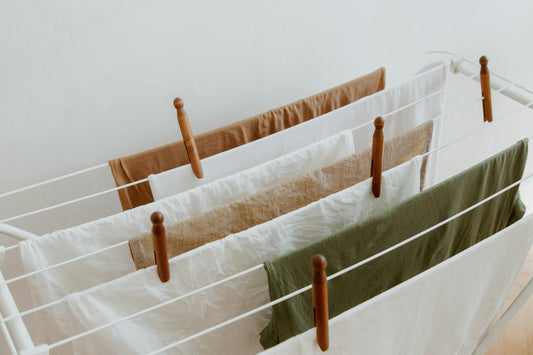 Fresh laundry hanging on a drying rack, secured with wooden clips.