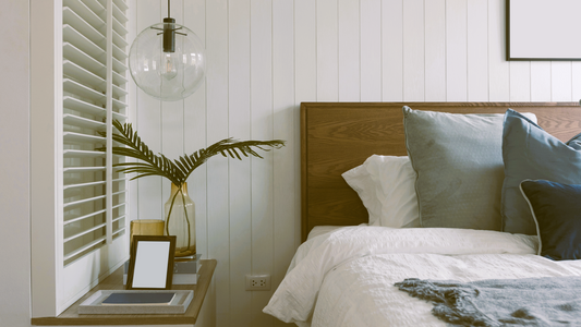 Bed styled with crisp white linen and a mix of decorative pillows.