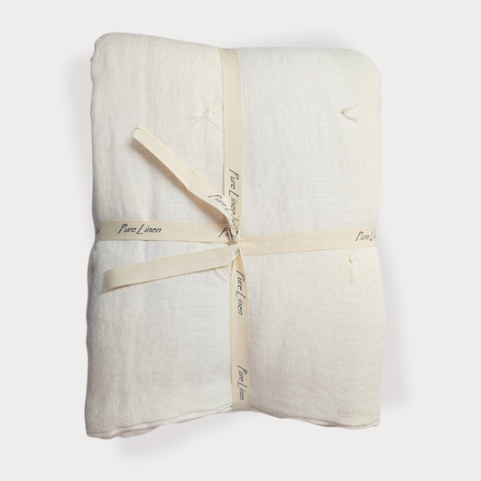 Folded white linen fabric with a beige ribbon on a white background
