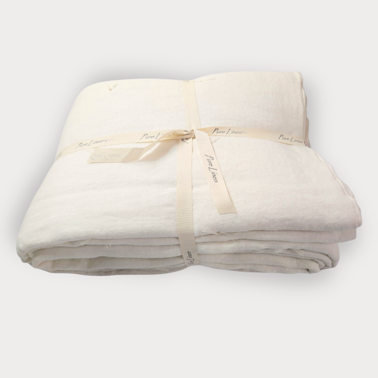 Folded beige blanket with a ribbon on a white background