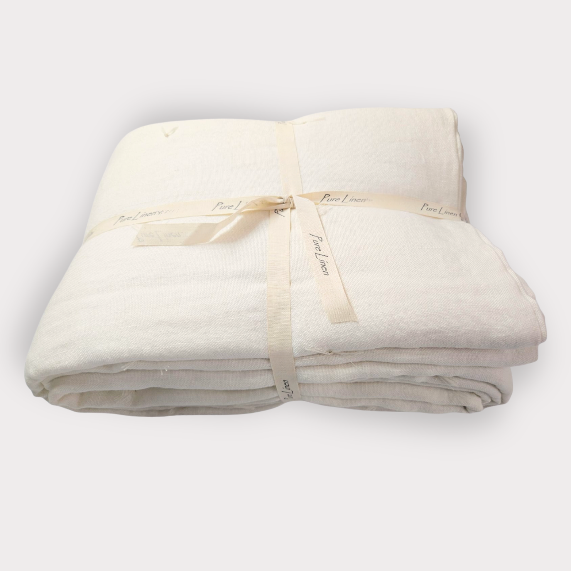 Folded beige blanket with a ribbon on a white background