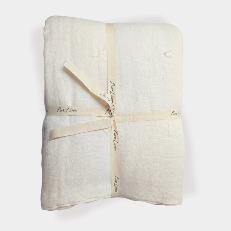 Handmade ivory linen quilt featuring soft stone-washed linen and hand-tied quilting details.