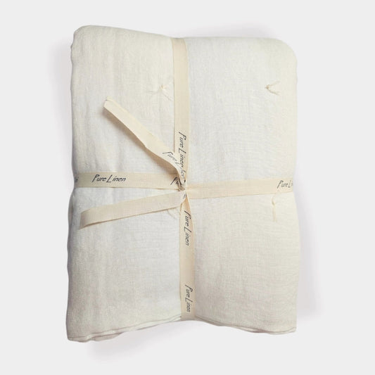 Handmade ivory linen quilt featuring soft stone-washed linen and hand-tied quilting details.